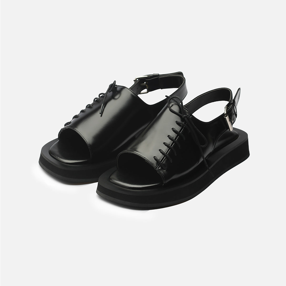 The THEN Black Leather Lace-Front Slingback Sandals feature a shiny finish, square toe, thick flat soles, lace-up fronts, and slingback straps. Handcrafted in Korea; shown against a plain white background.