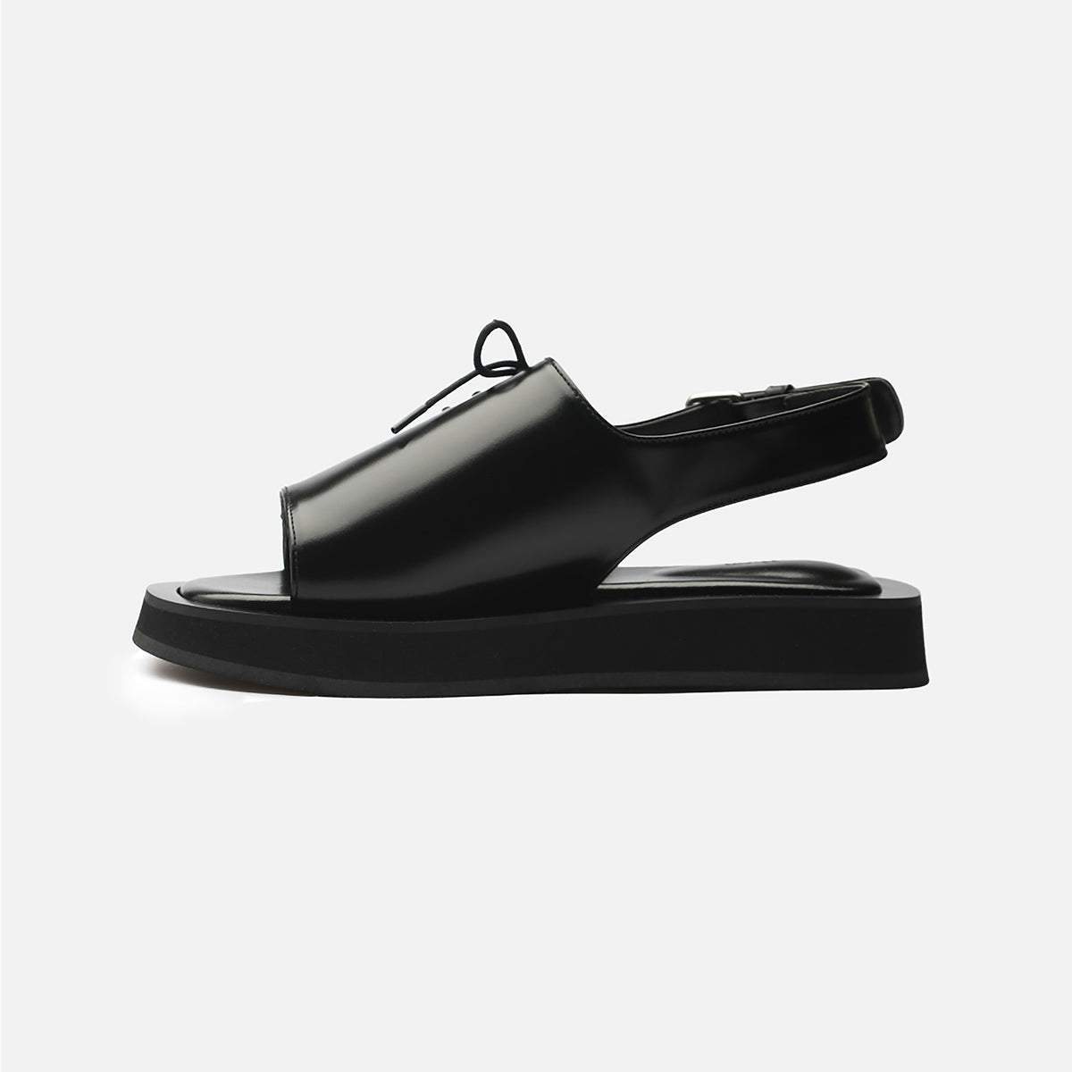 The Black Leather Lace-Front Slingback Sandals by THEN, handcrafted in Korea, feature a square toe, thick flat sole, closed lace-detailed upper, and open heel strap—shown against a plain white background.