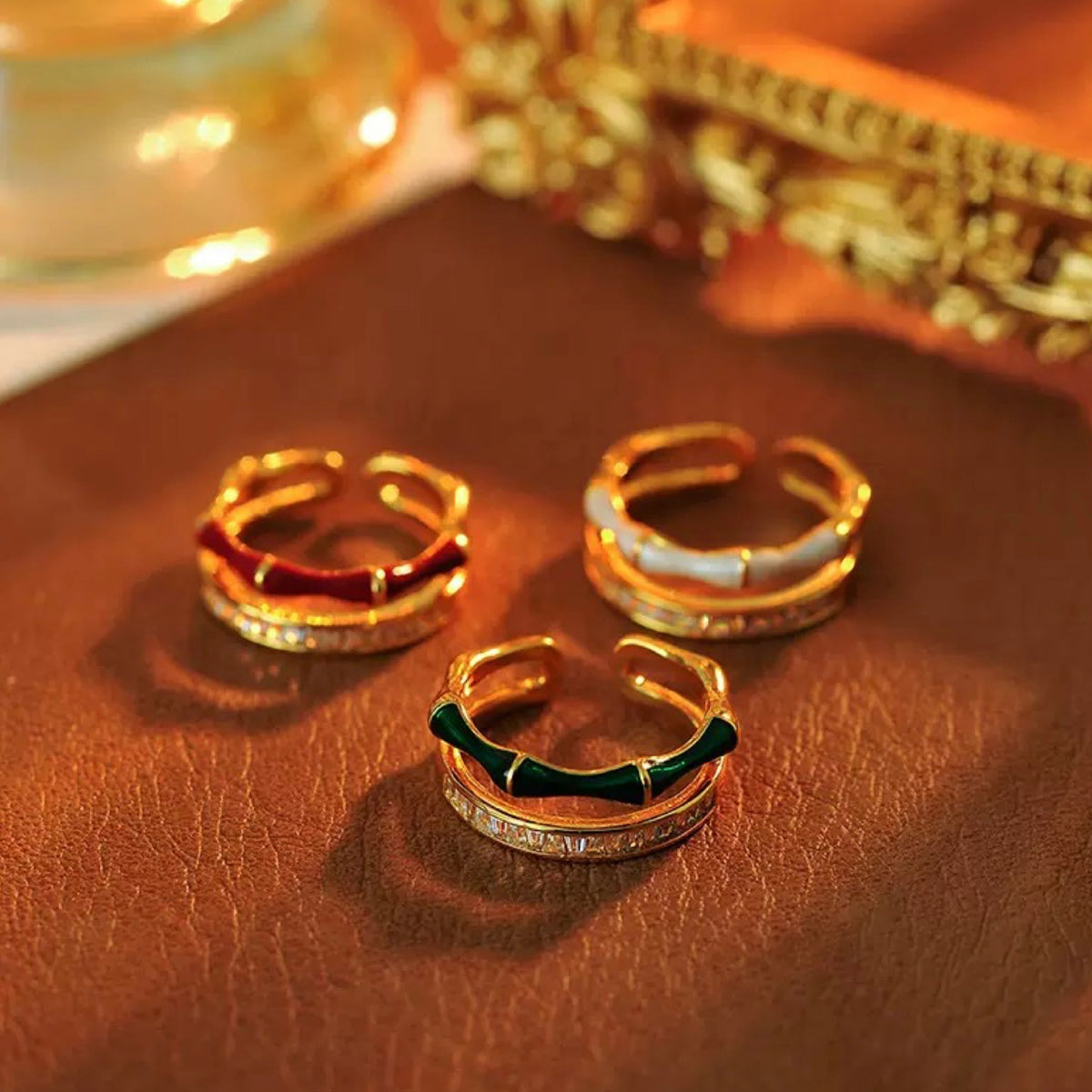 Three gold hoop earrings on a brown leather surface