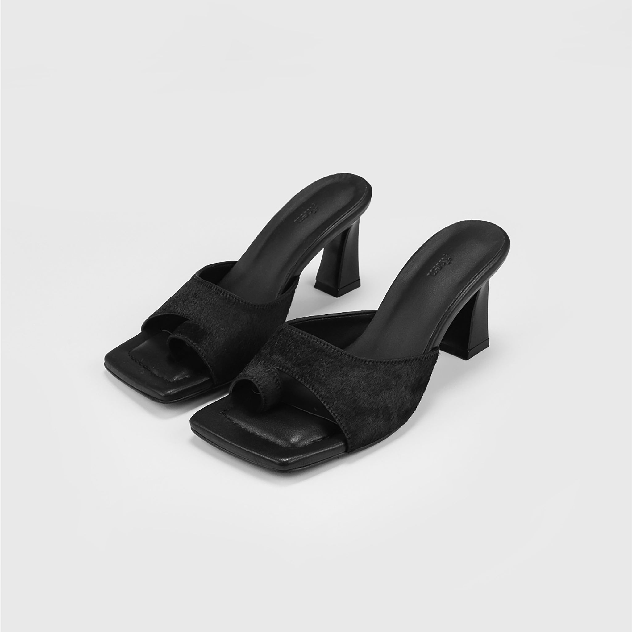 The THEN Black Suede Toe-Ring Heeled Mules feature a minimalist design with square open toes and wide textured straps, handcrafted in Korea and shown against a plain light gray background.