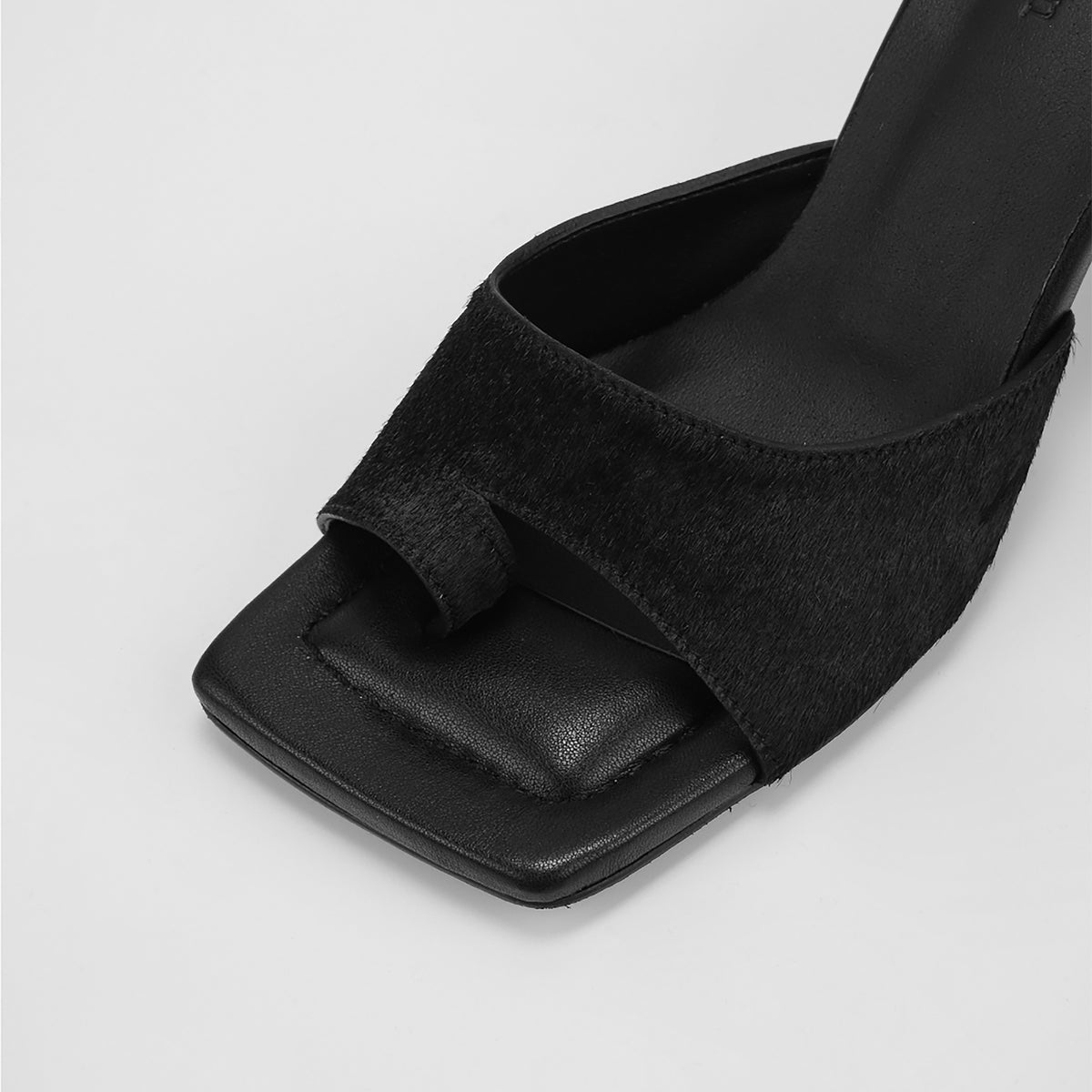 Close-up of THEN's Black Suede Toe-Ring Heeled Mules, featuring a square toe, wide textured strap, and toe loop. Handcrafted in Korea and displayed on a plain white background.