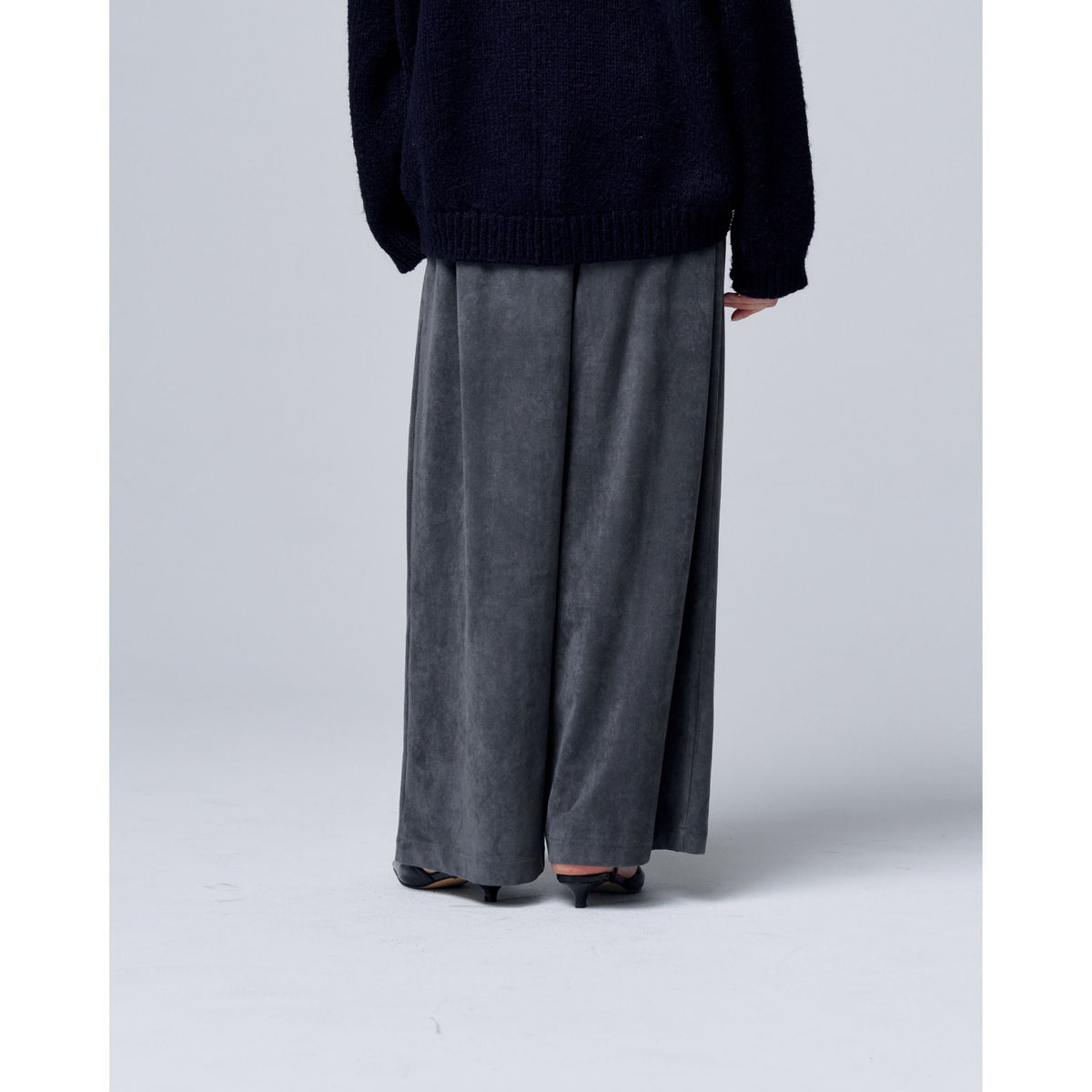 A person, shown from the waist down against a plain background, wears ODDPRESENT Velour Suede Pants with Elastic Waistband in gray and a dark long-sleeve top.