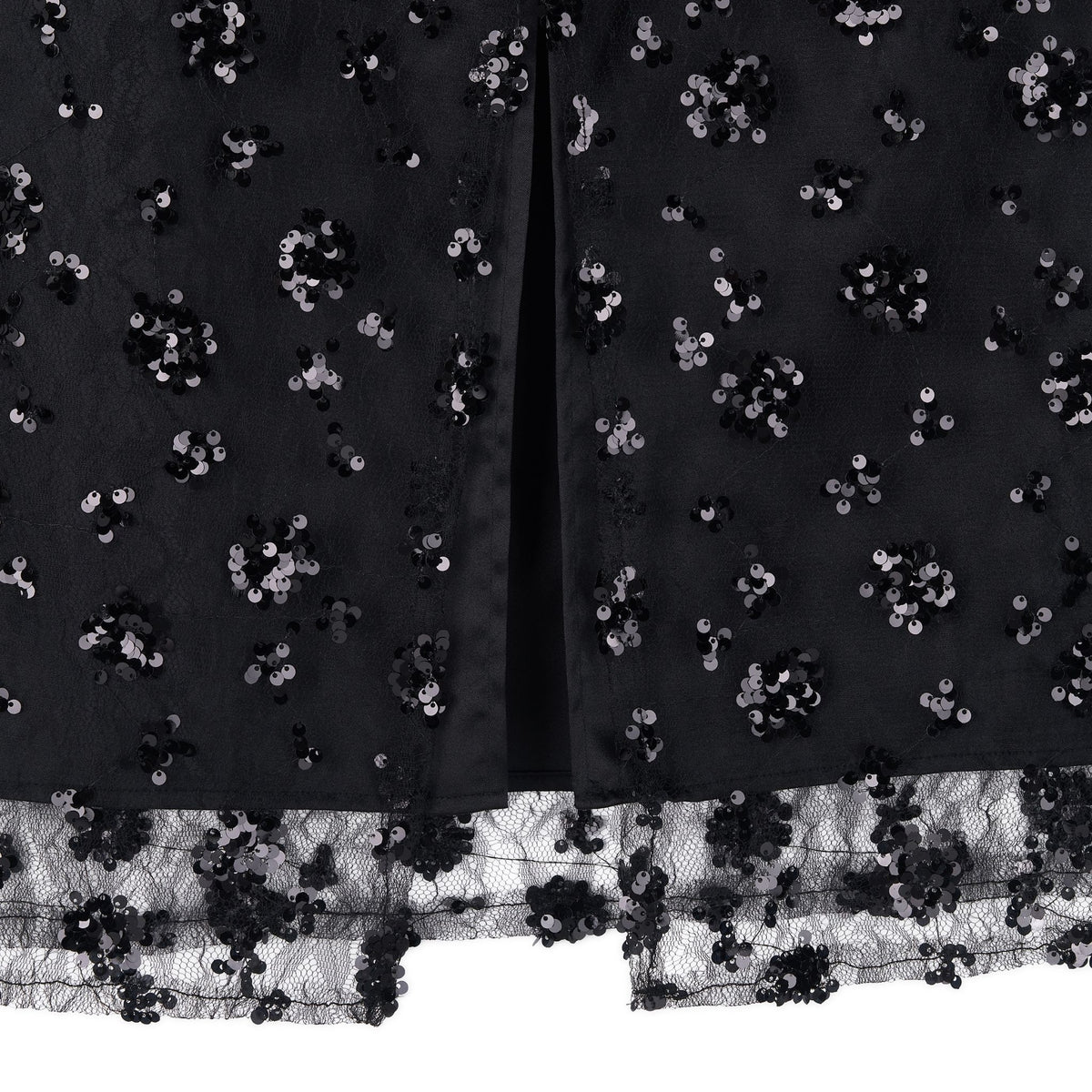 Close-up of the ODDPRESENT Sequin Beaded Skirt with Floral Detailing, featuring clusters of shiny black sequins, lace trim at the hem, and a center slit—ideal for adding sparkle and elegance to evening events.