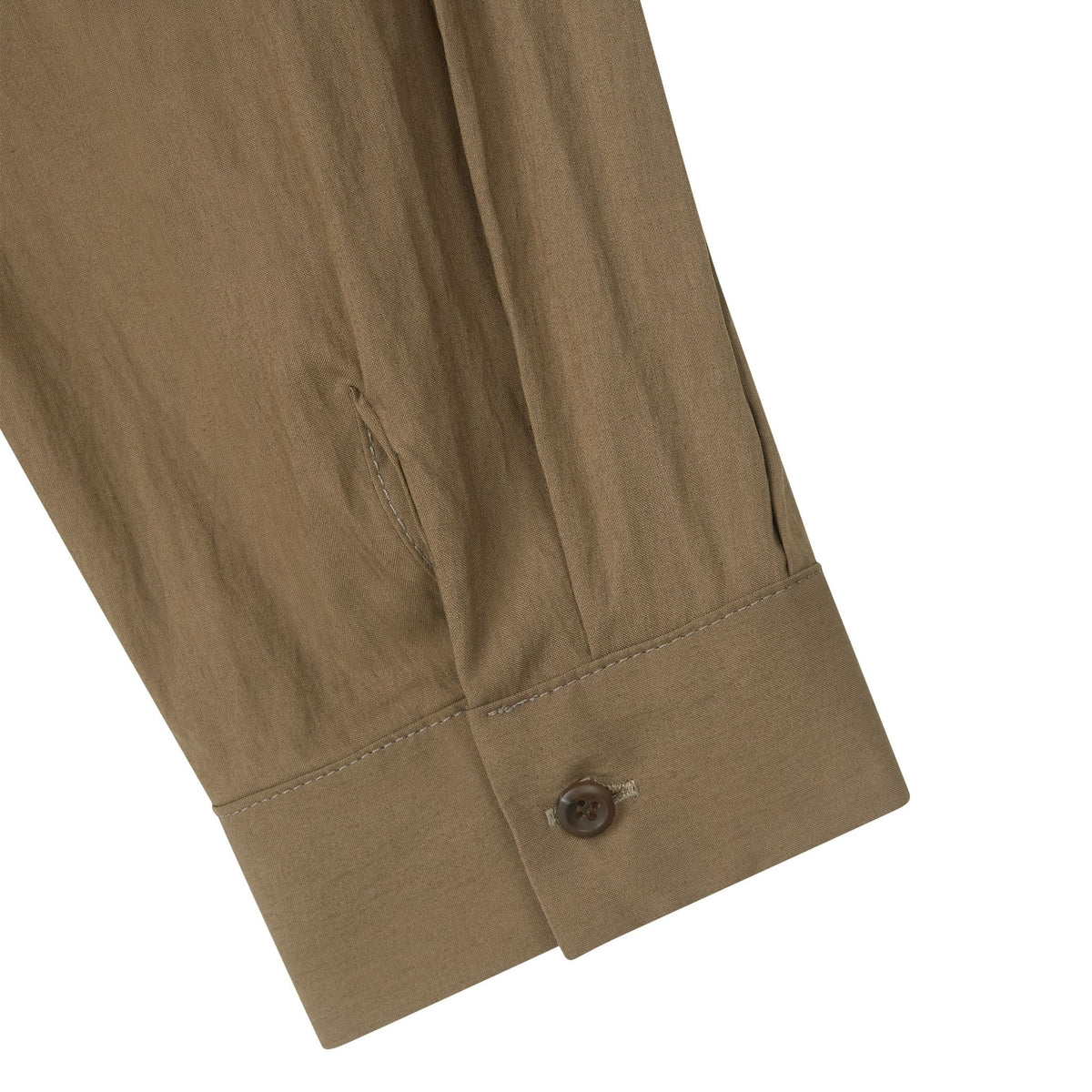 Close-up of a brown shirt cuff with a button on a white background