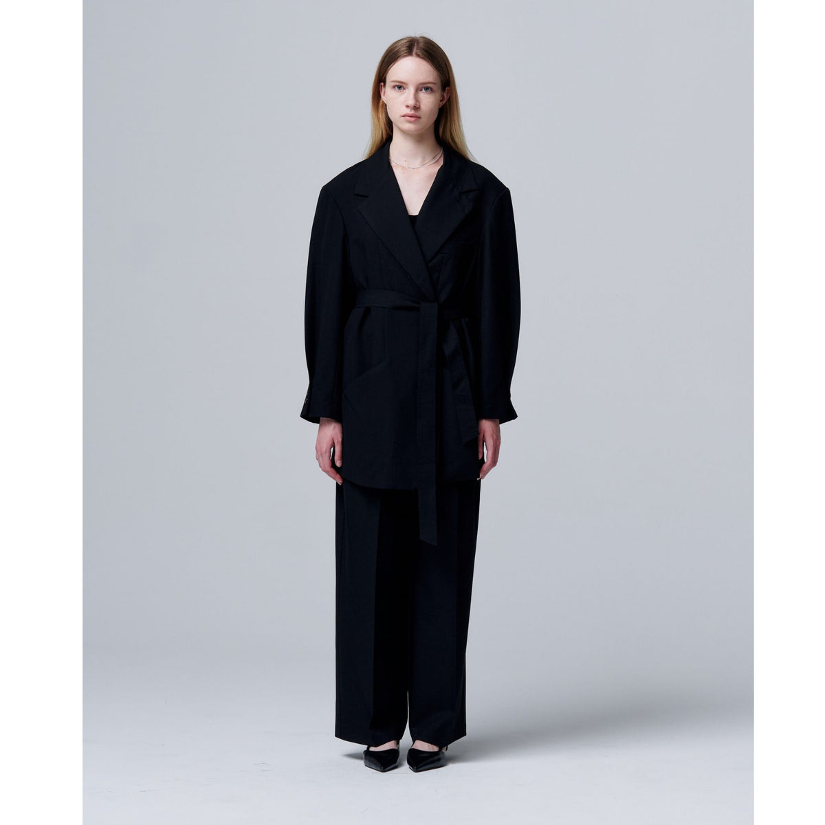 Woman wearing a black outfit against a plain background