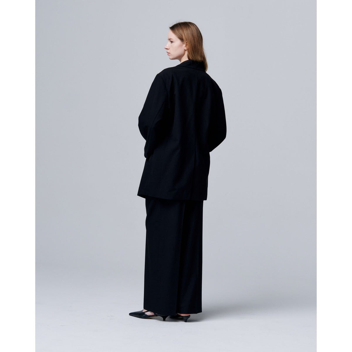 Person wearing a black outfit on a plain background