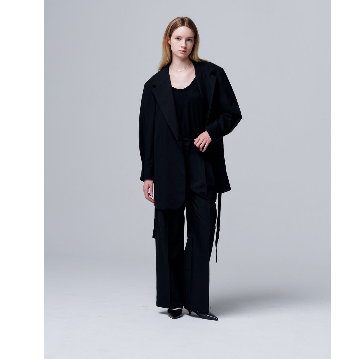 Woman wearing a black outfit on a plain background