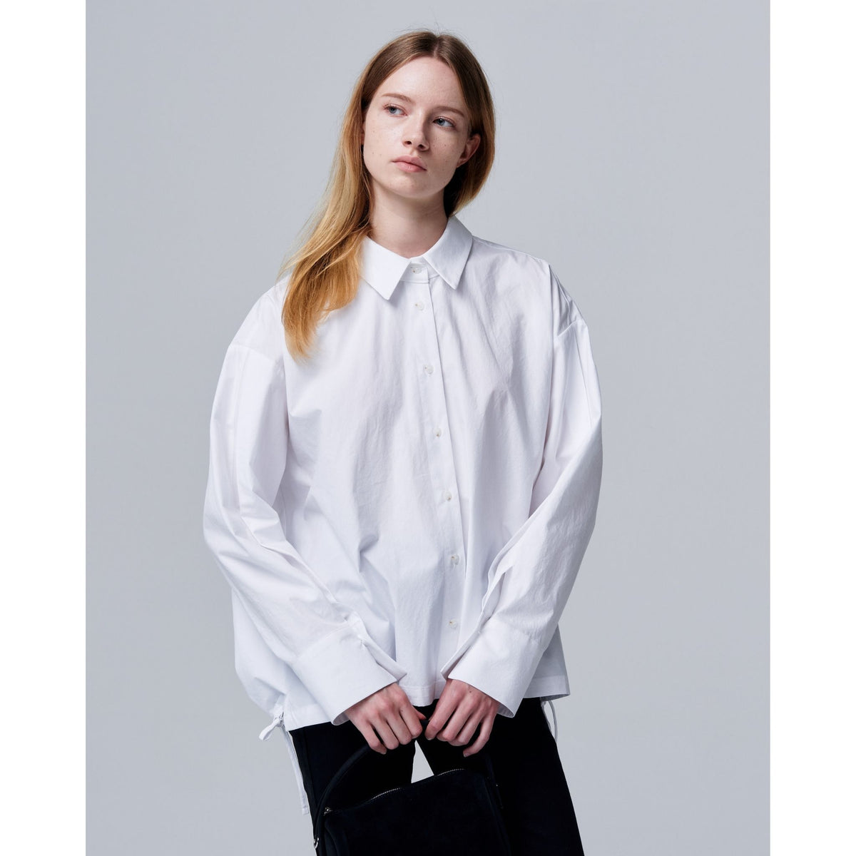 Person wearing a white shirt against a plain background