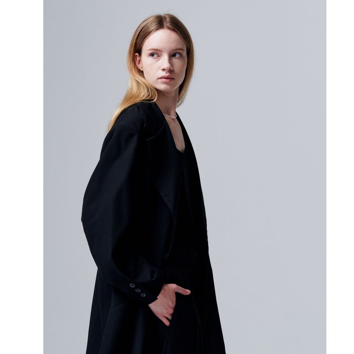 Woman wearing a black dress against a plain background