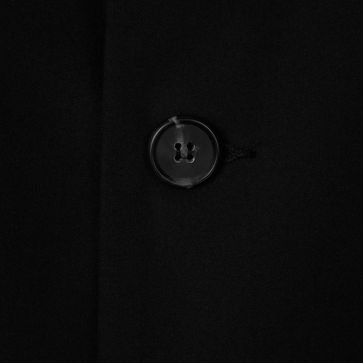 Close-up of a button on a black fabric background