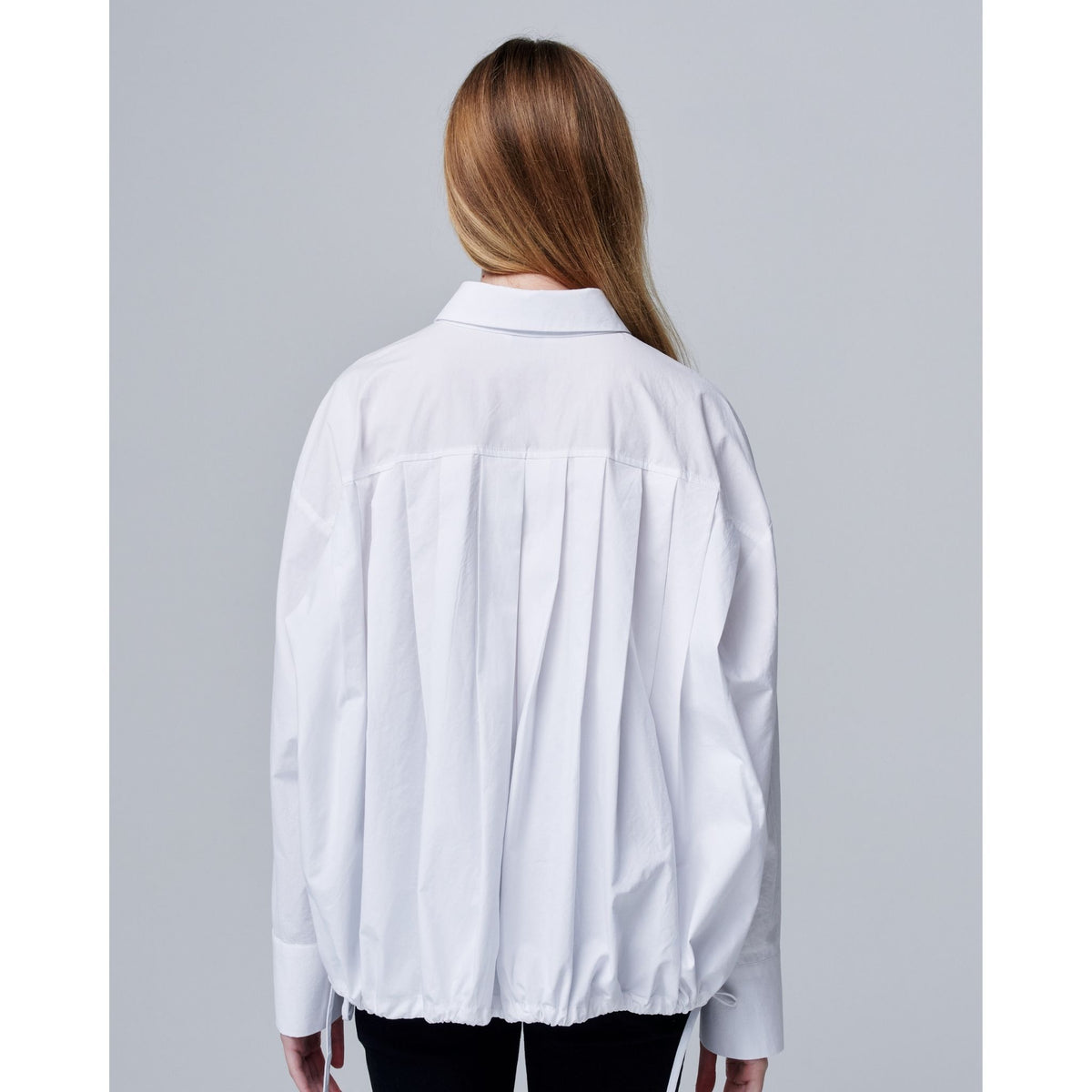 Person wearing a white shirt with a gray background