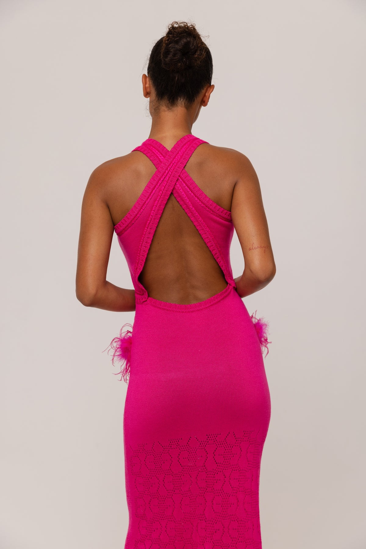 Fuchsia evening gown with open back on a plain background