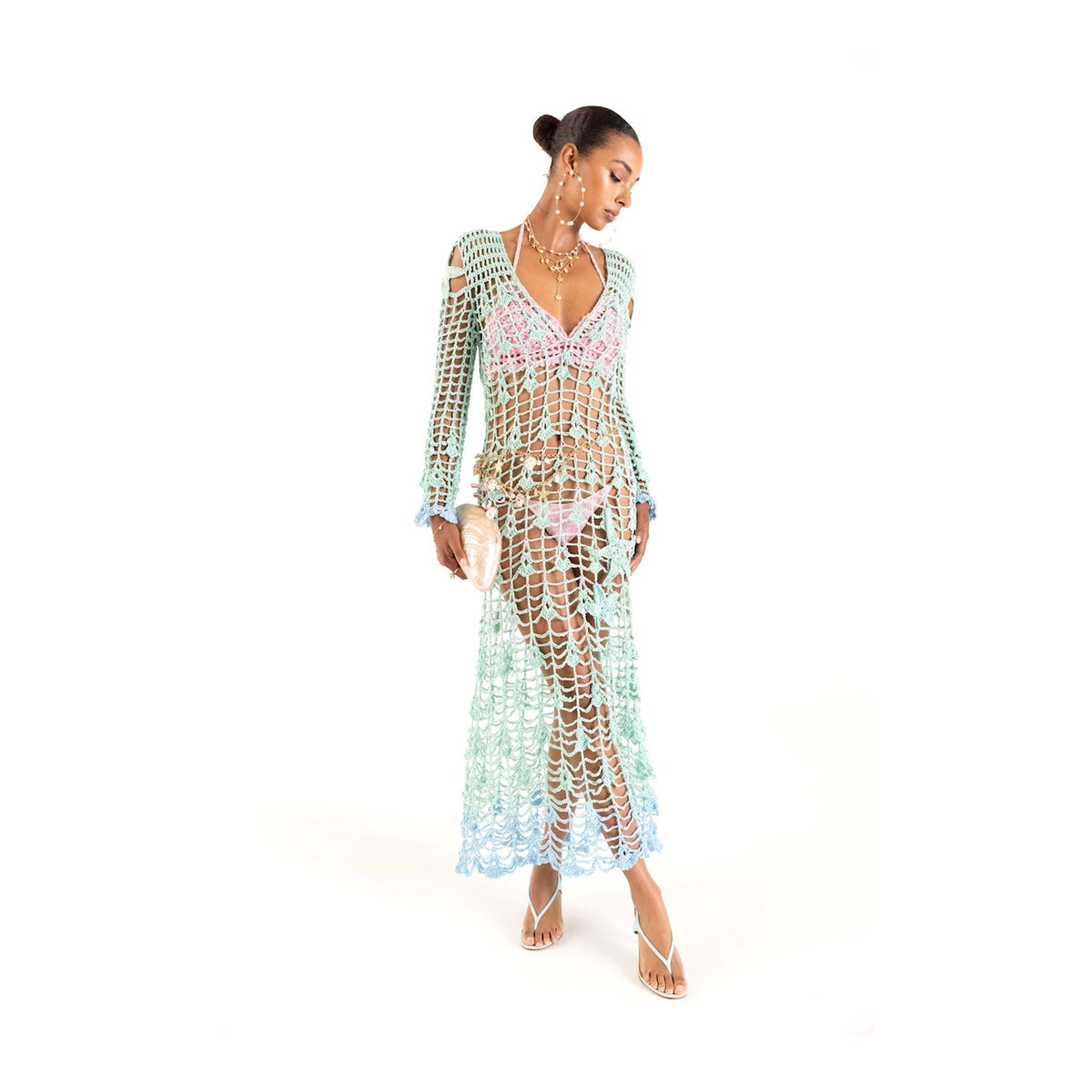 A woman models the ANDREEVA Aqua Marine Handmade Maxi Cover-Up Dress over a pink bikini, accessorized with hoop earrings, layered necklaces, heeled sandals, and a small bag against a white background.