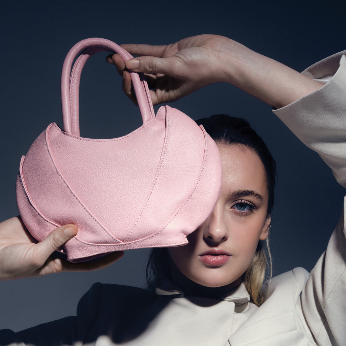 Model covering her face with the Etherea mini Pink