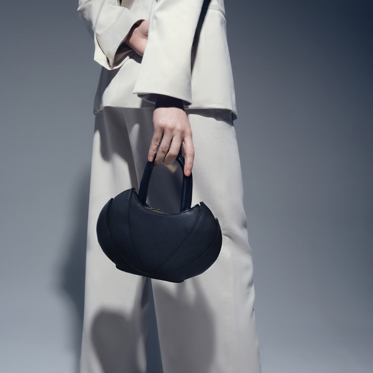 Model wearing white suit and pants with the Etherea Mini Black