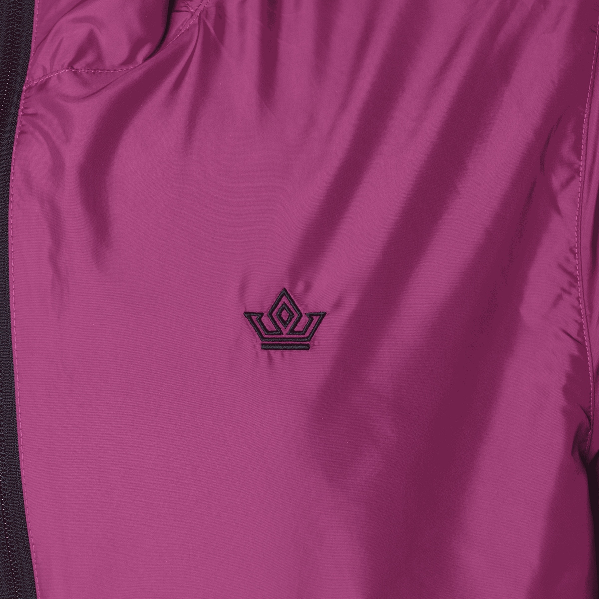 Close-up of a purple garment with a logo on a dark background