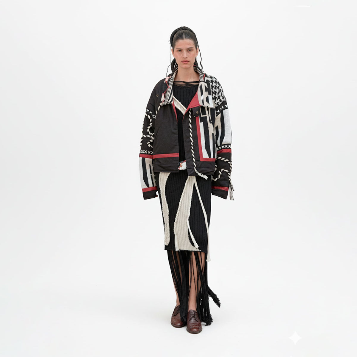 Model wearing a black and white patterned outfit on a white background