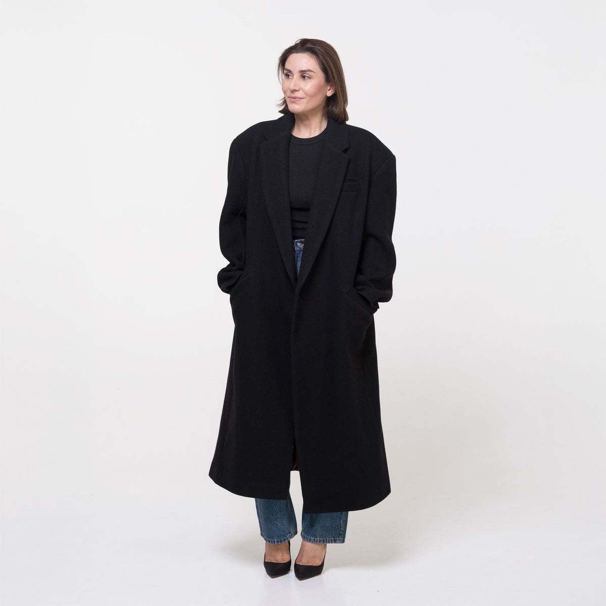 Woman wearing a black coat on a white background