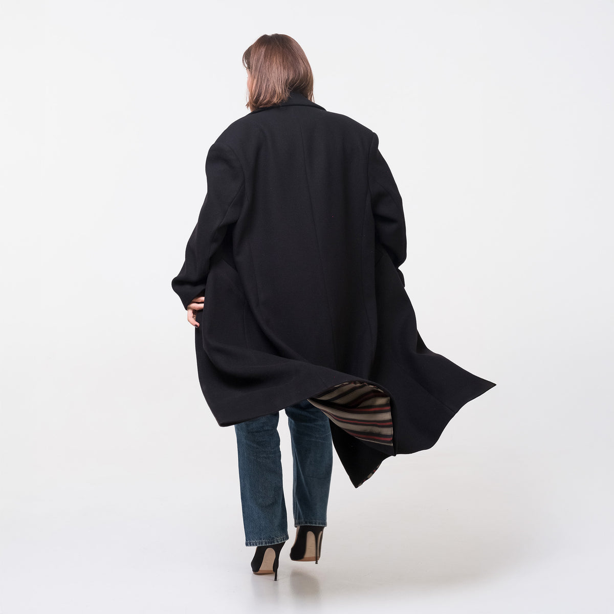 Person wearing a black coat on a white background