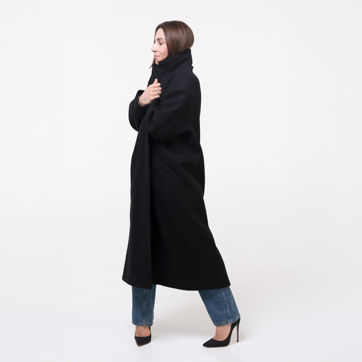 Woman wearing a black coat on a white background