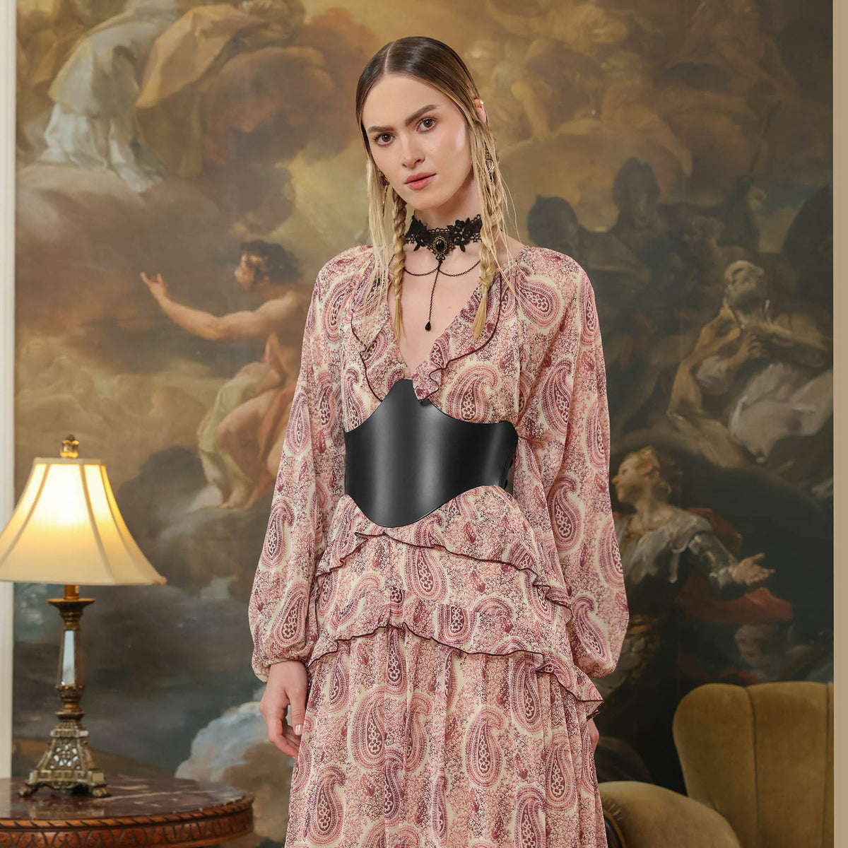 Woman in a patterned dress standing in front of an artistic painting