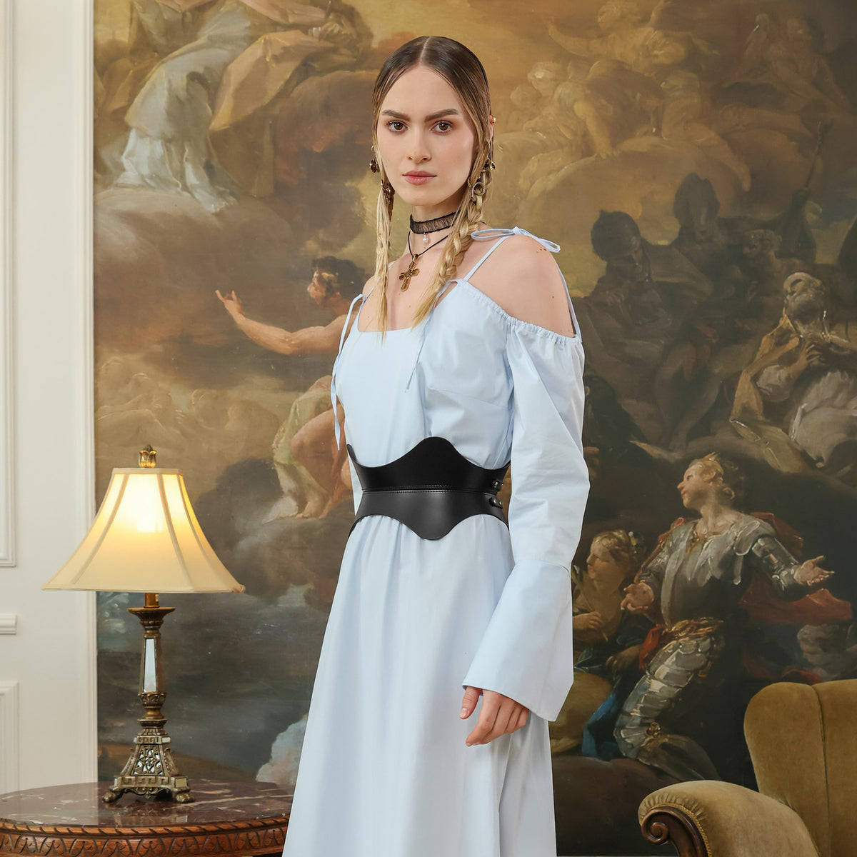 Woman in a white dress standing in front of a classical painting