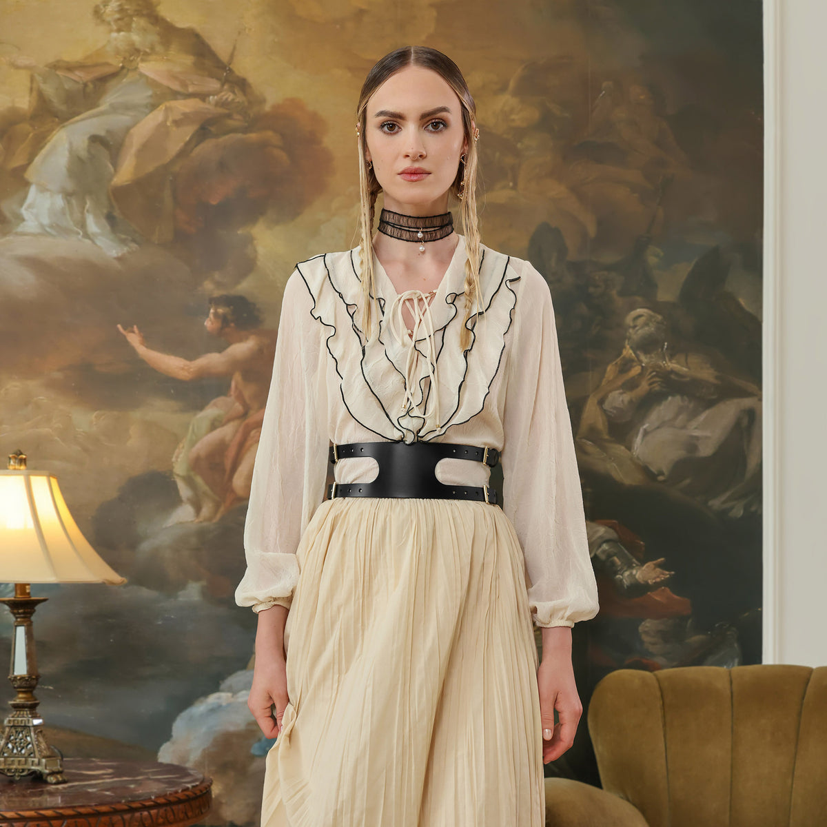 Woman in a vintage-style outfit standing in front of a classical painting