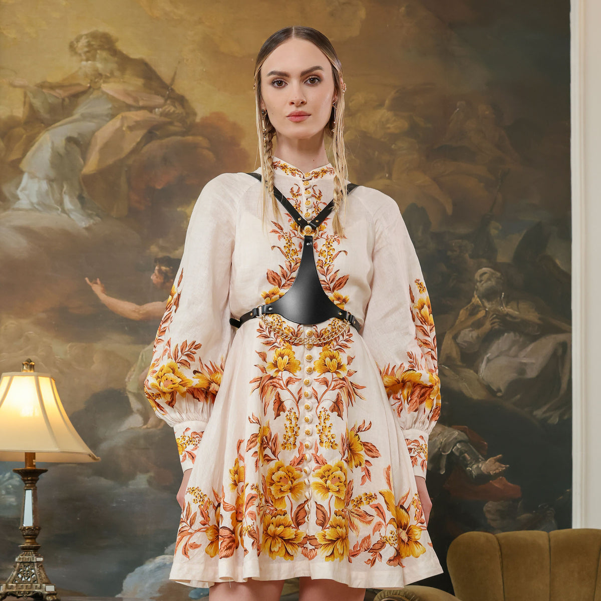 Woman wearing a floral dress in front of an artistic mural.