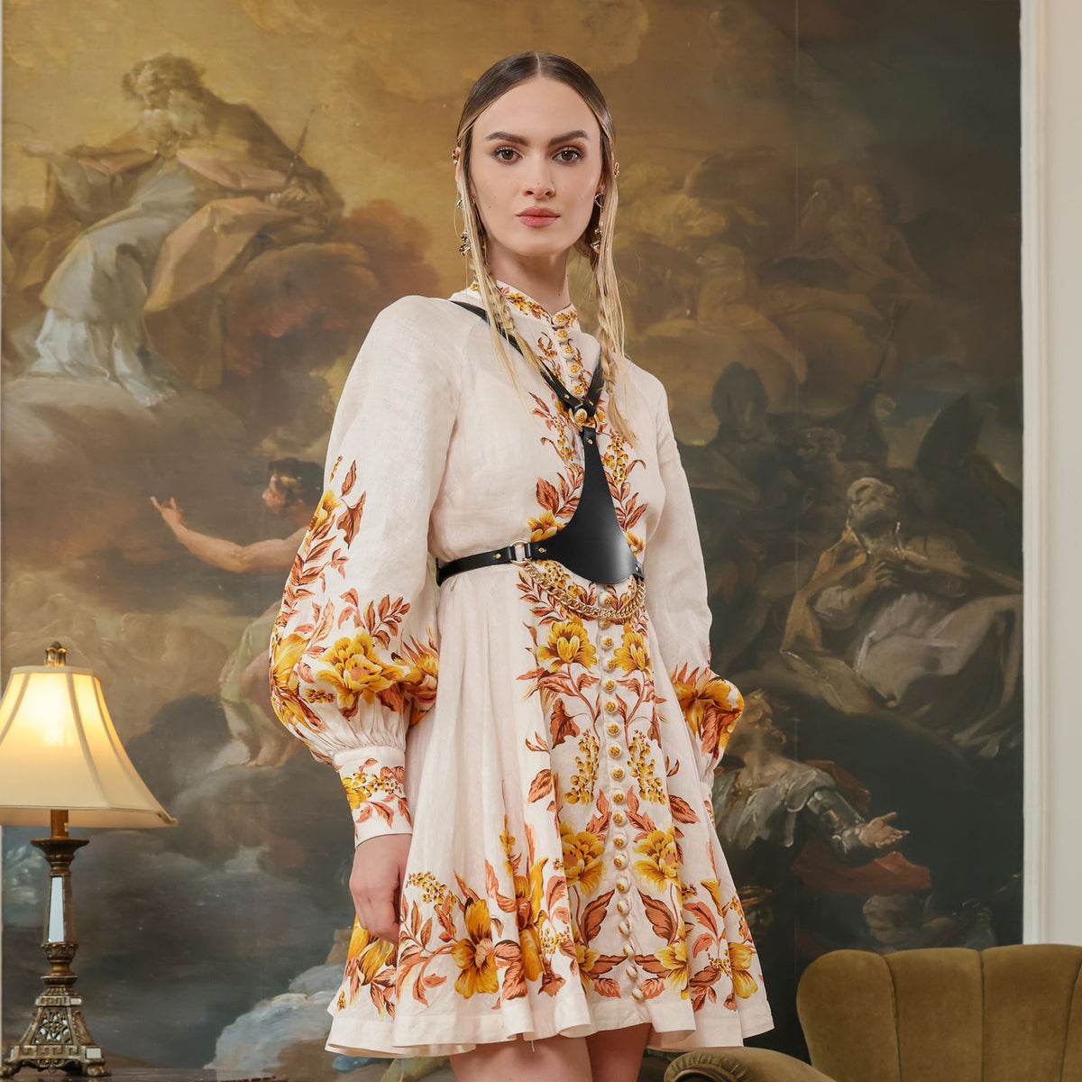Woman in a floral dress standing in front of a classical painting