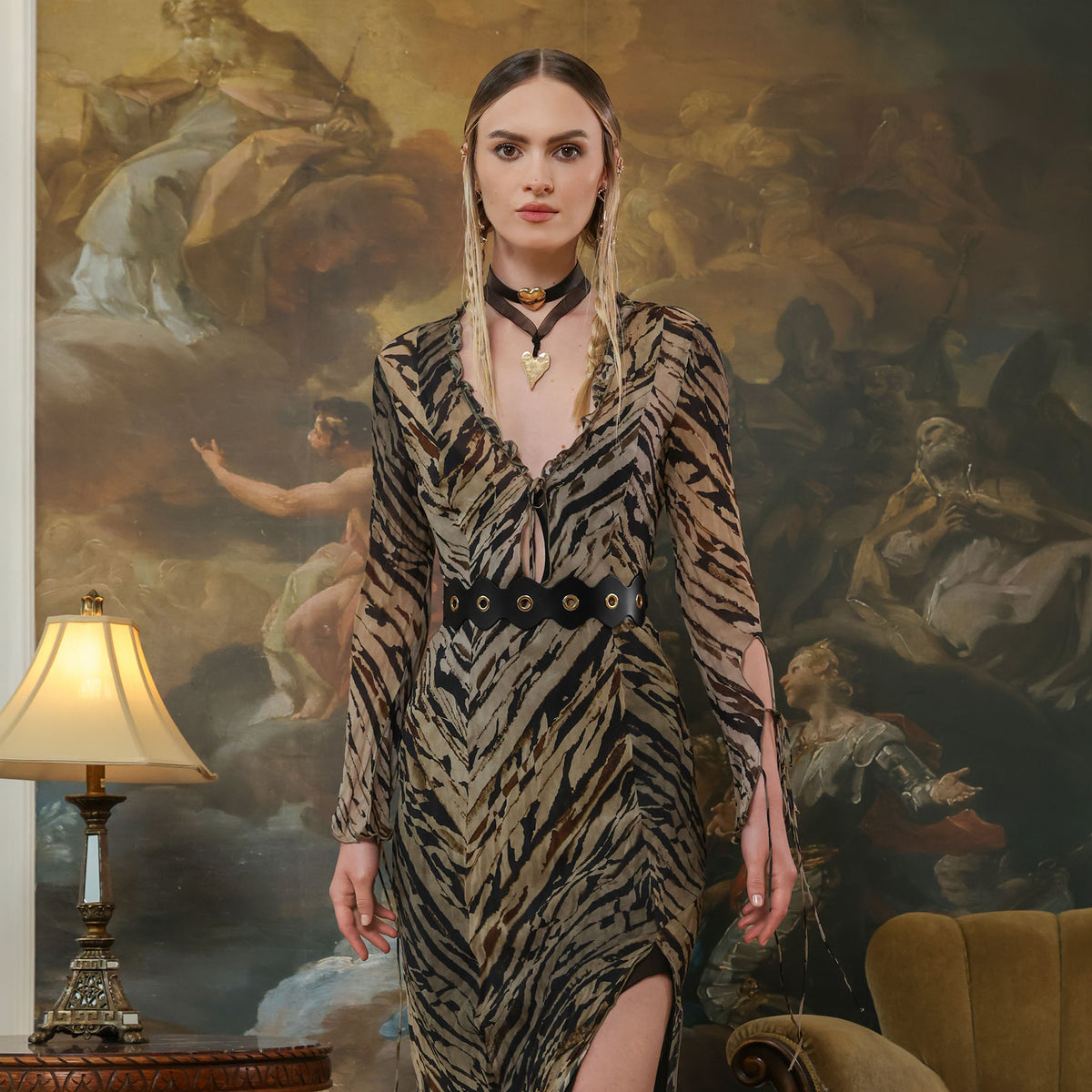 Woman in a zebra print dress standing in front of a large painting