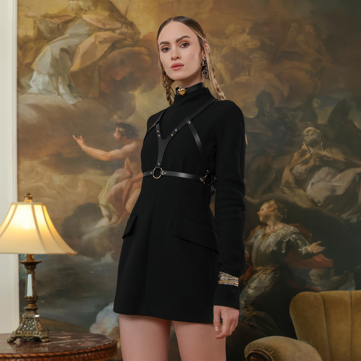 Woman in a black outfit standing in front of a classical painting