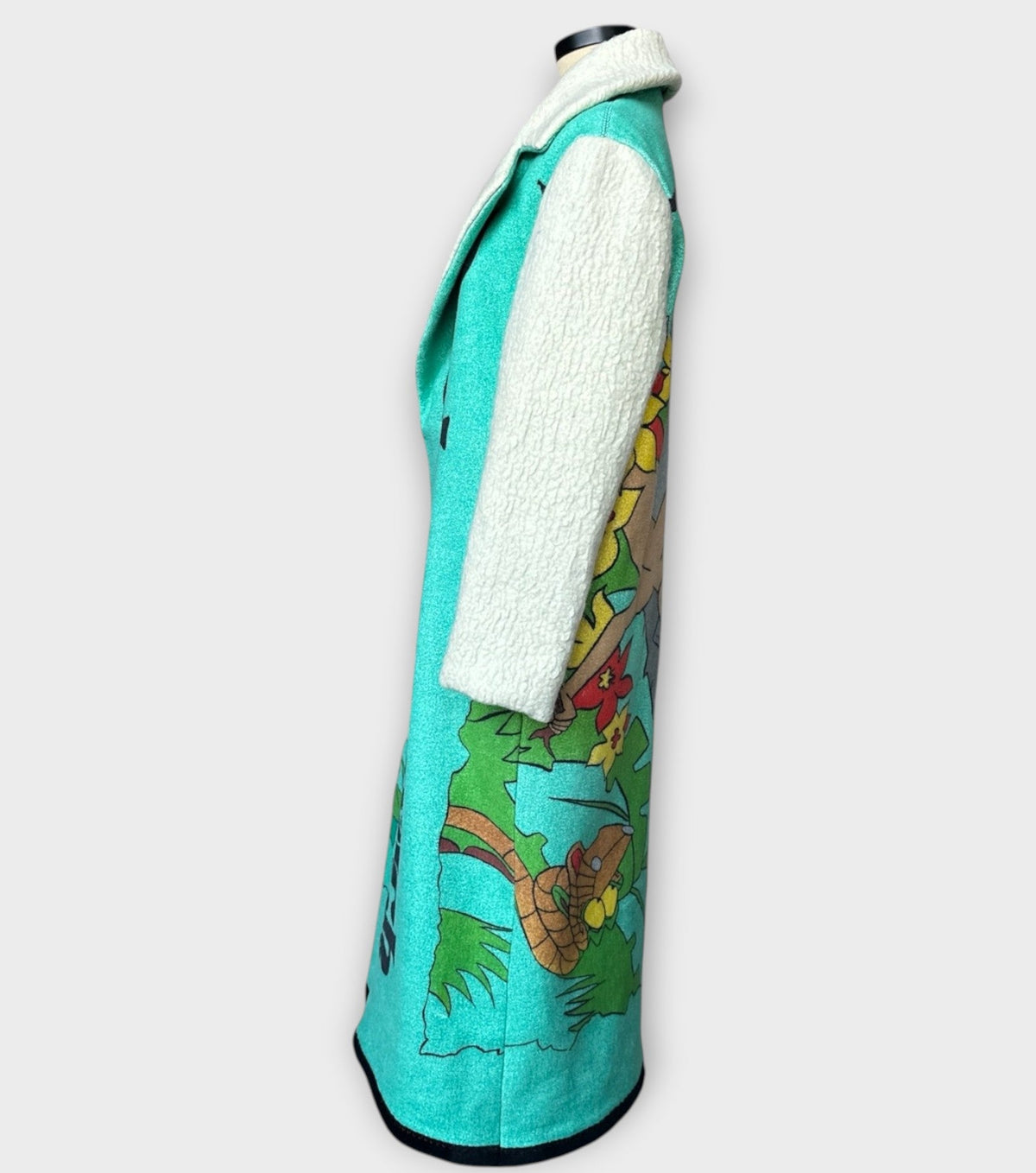 STUDIO WUNDERBAR Jungle Book Coat: turquoise graphic long coat with a Bagheera panther illustration from The Jungle Book and cream sleeves, upcycled one-of-a-kind coat, alternate angle, buy at DOORS NYC