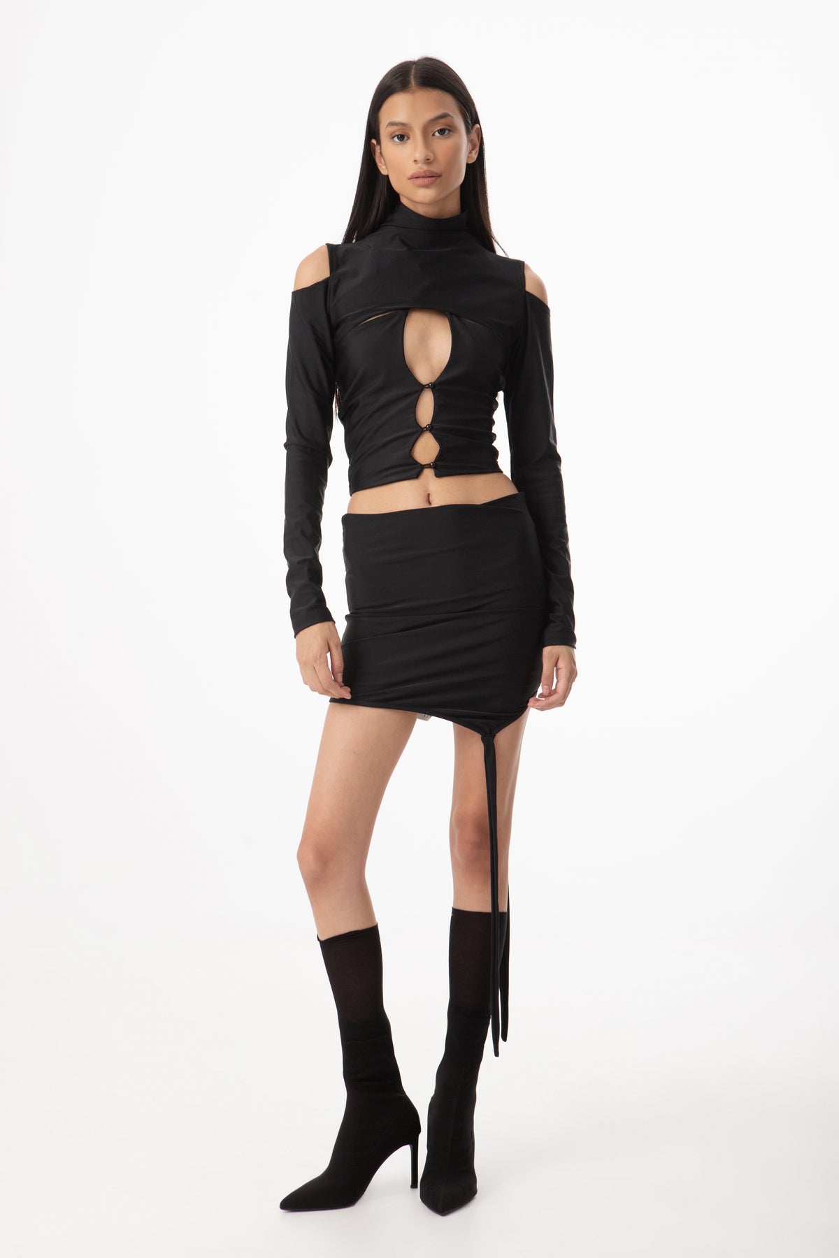 Woman wearing a black outfit with cut-out design on a white background