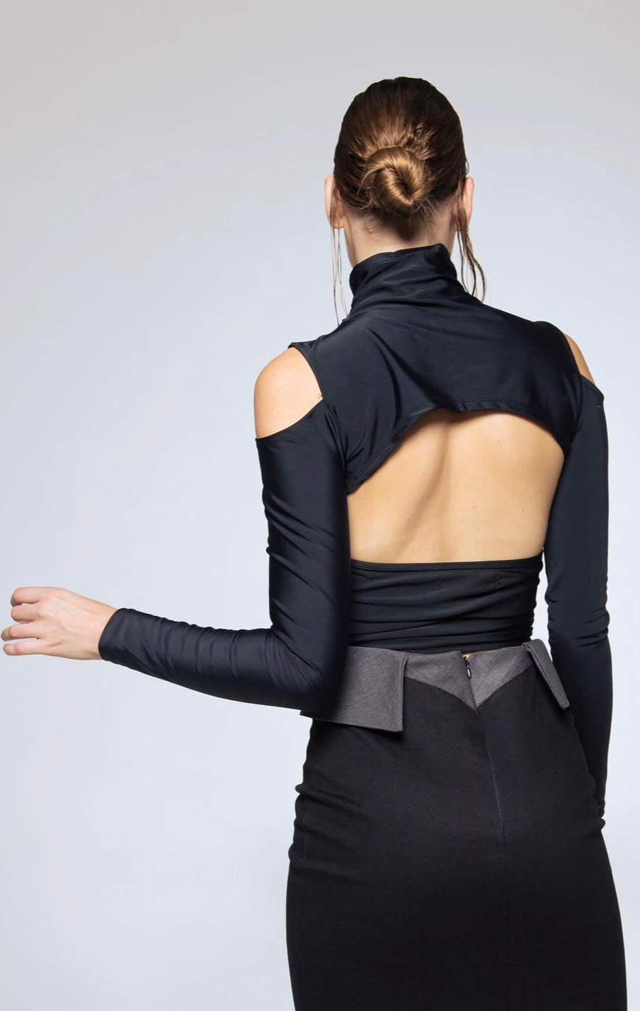 Person wearing a black outfit with a unique design on a white background