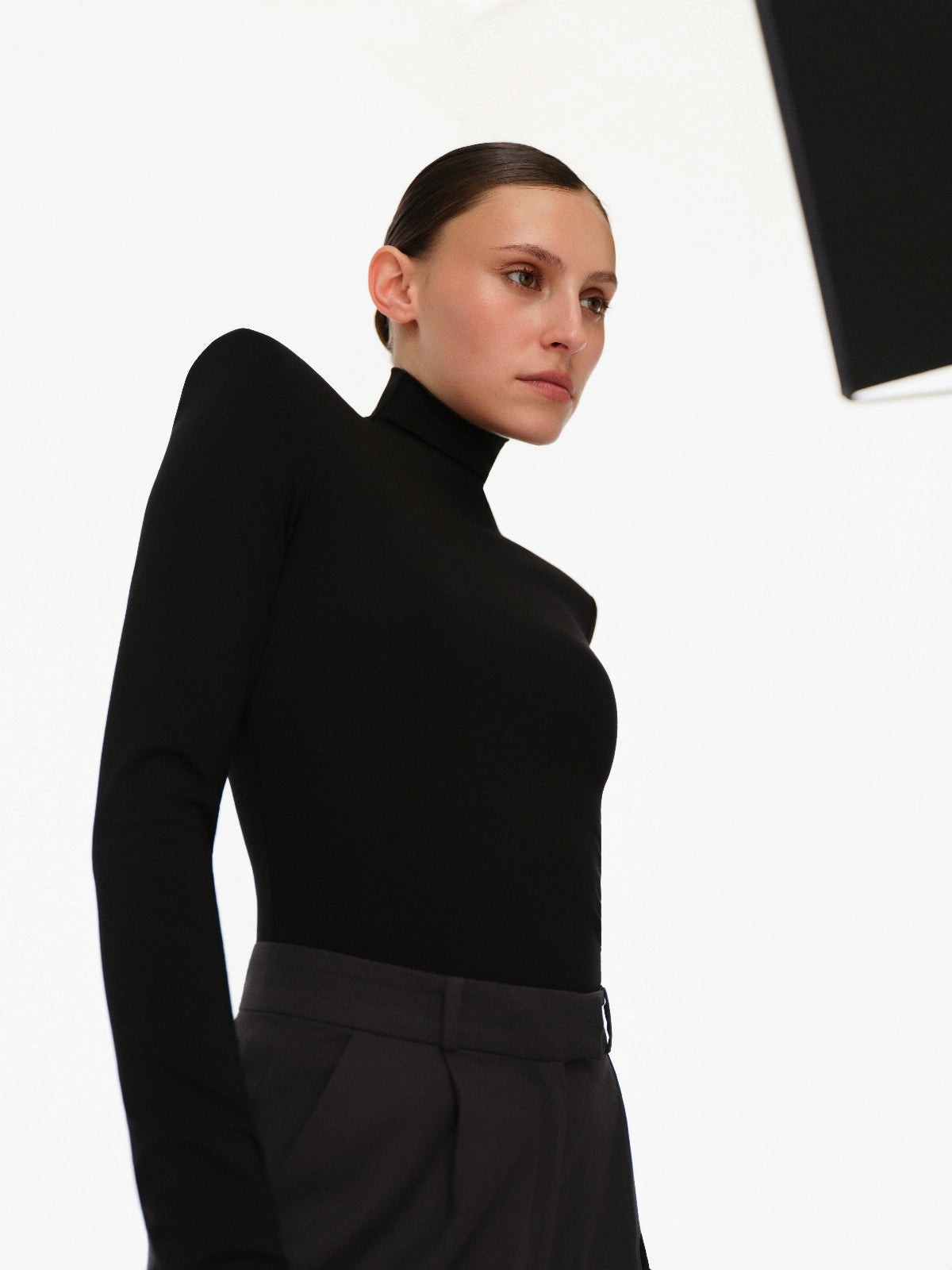 DAR ANN STUDIO black structured high-neck top worn by model, women's shoulder-pad top, buy at DOORS NYC