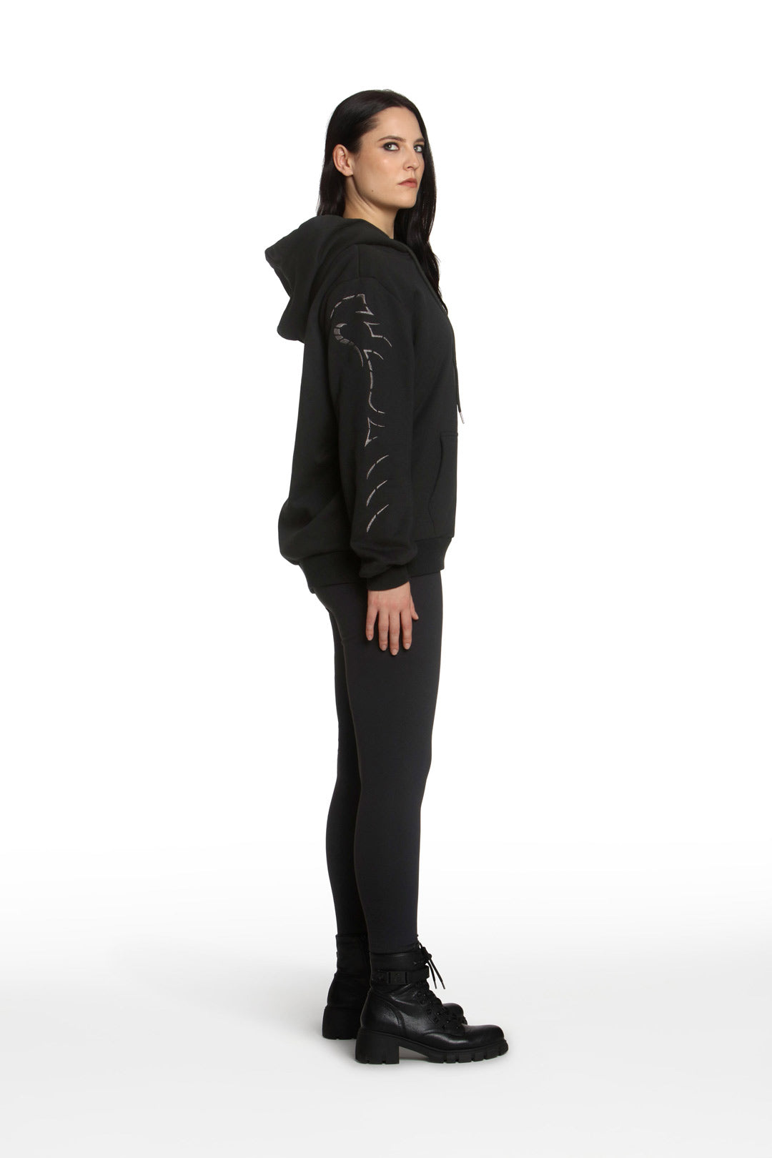 Person wearing a black hoodie with text on the back against a white background