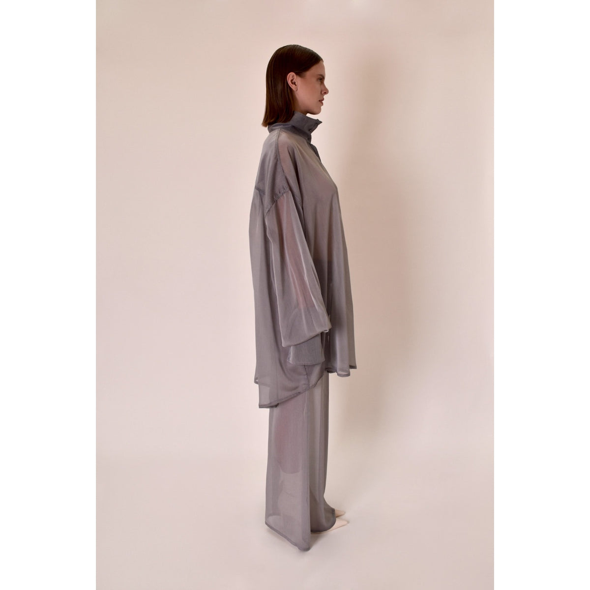 Woman wearing a silver outfit against a plain background