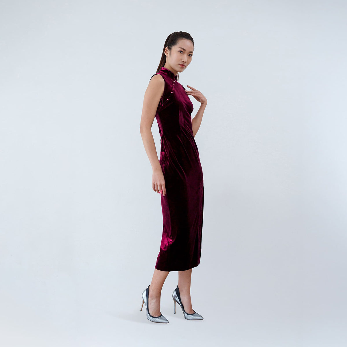 Qipology crimson red velvet sleeveless qipao dress with Mandarin collar, beaded detail and front slit, worn by model, look 3, buy at DOORS NYC