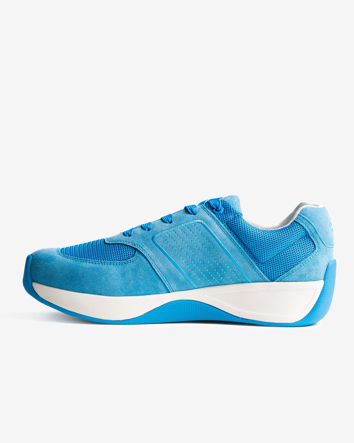 Blue athletic shoe with white sole on a light gray background