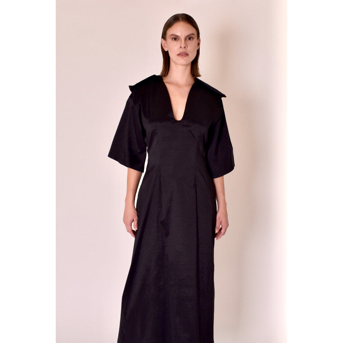 Woman wearing a black dress with a plain background