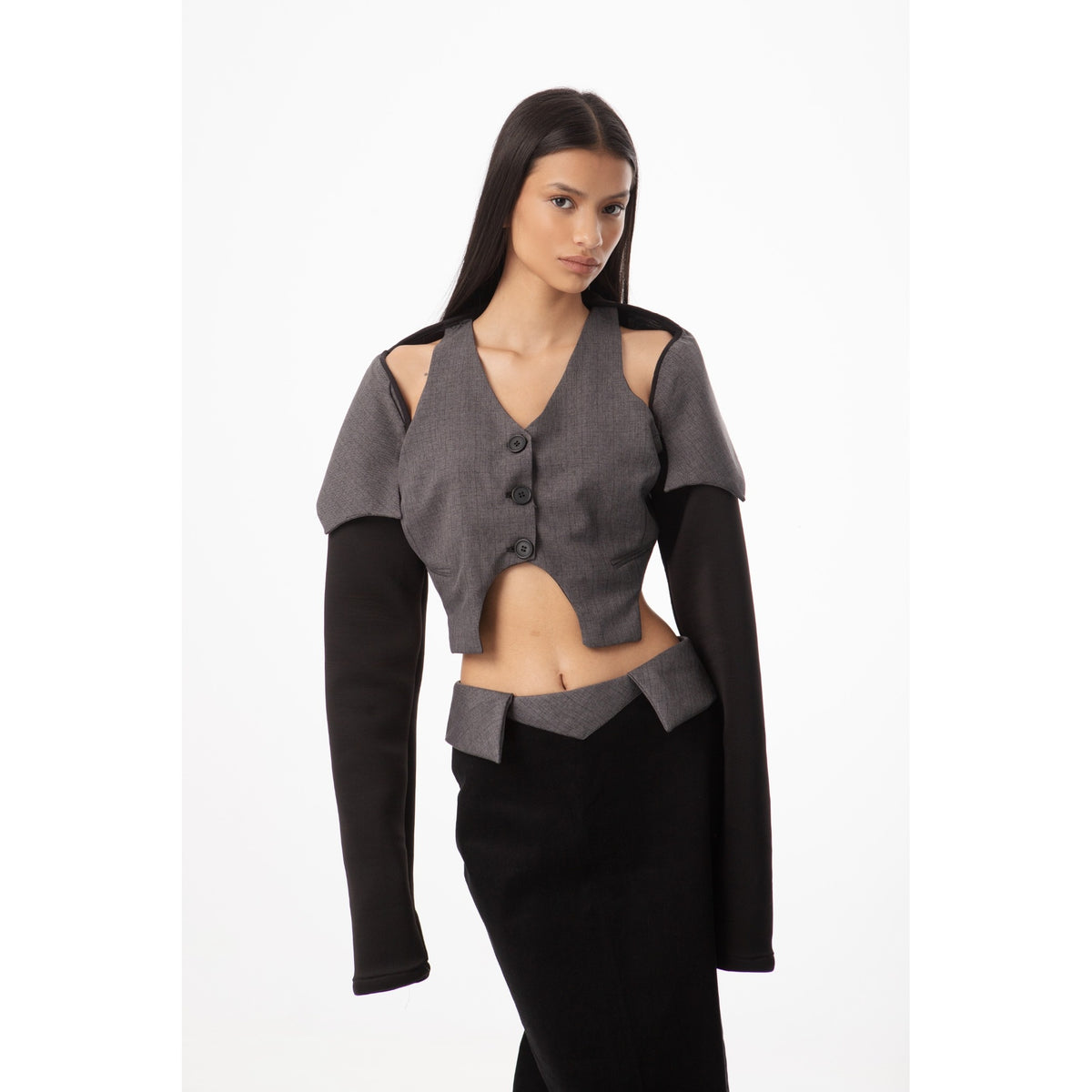 Woman wearing a gray and black outfit with cut-out shoulders on a white background