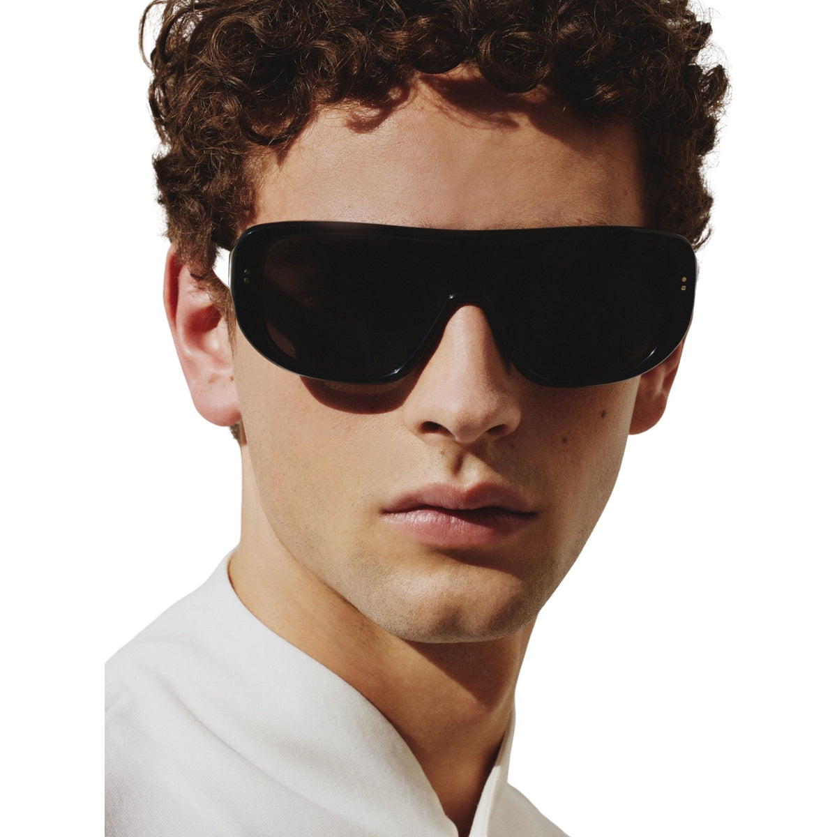 Man wearing black sunglasses with a white shirt on a white background