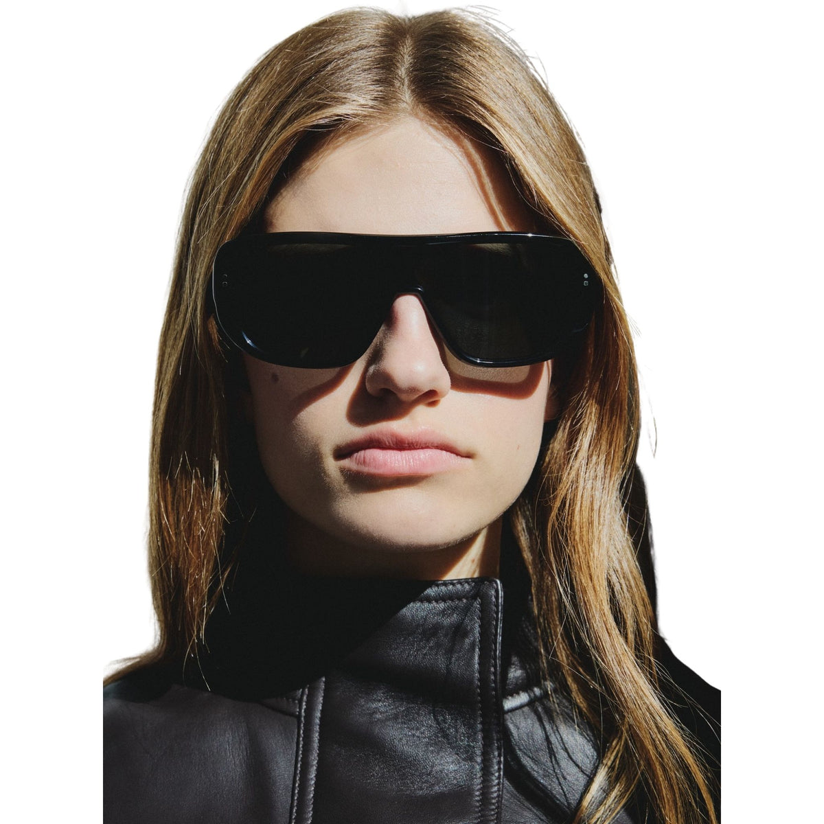 Woman wearing black sunglasses and a black leather jacket on a white background
