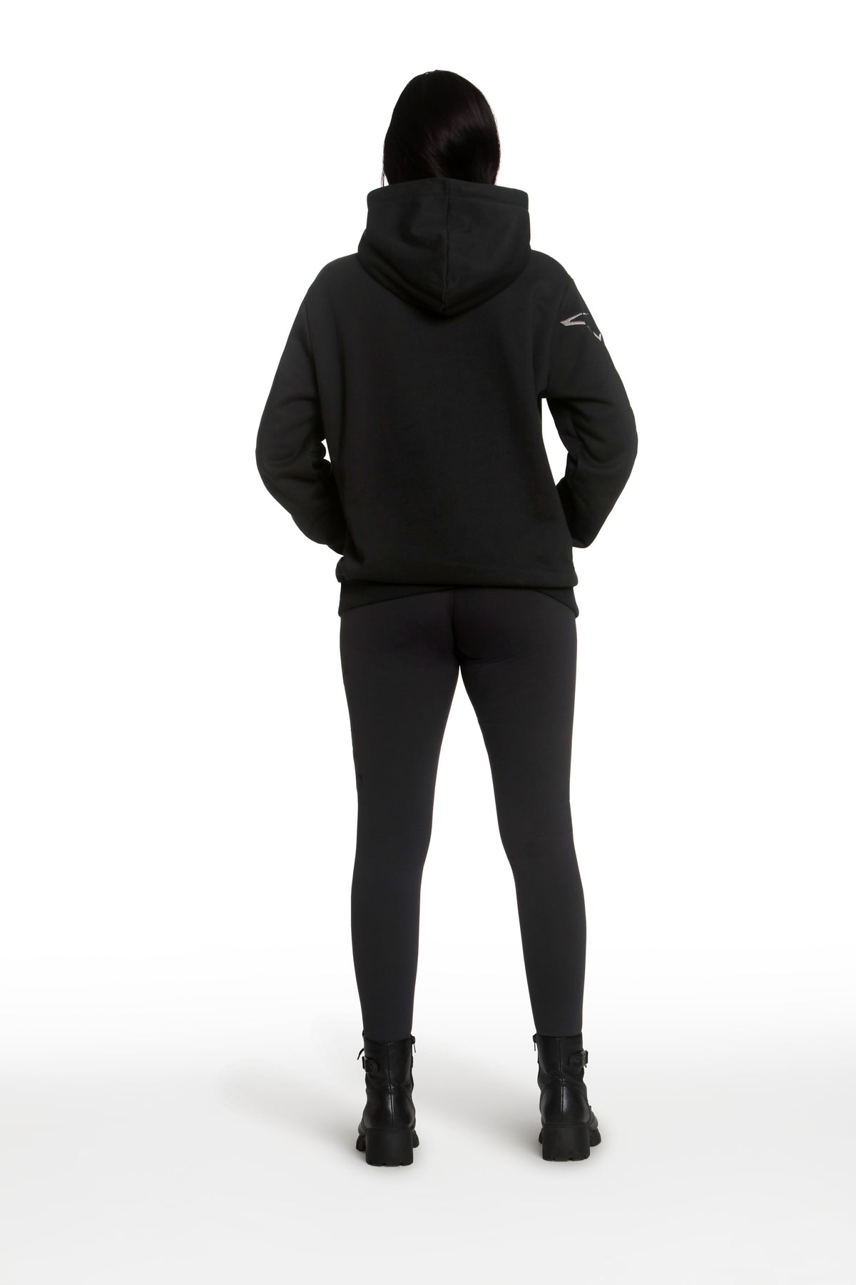 Person wearing a black hoodie and pants on a white background