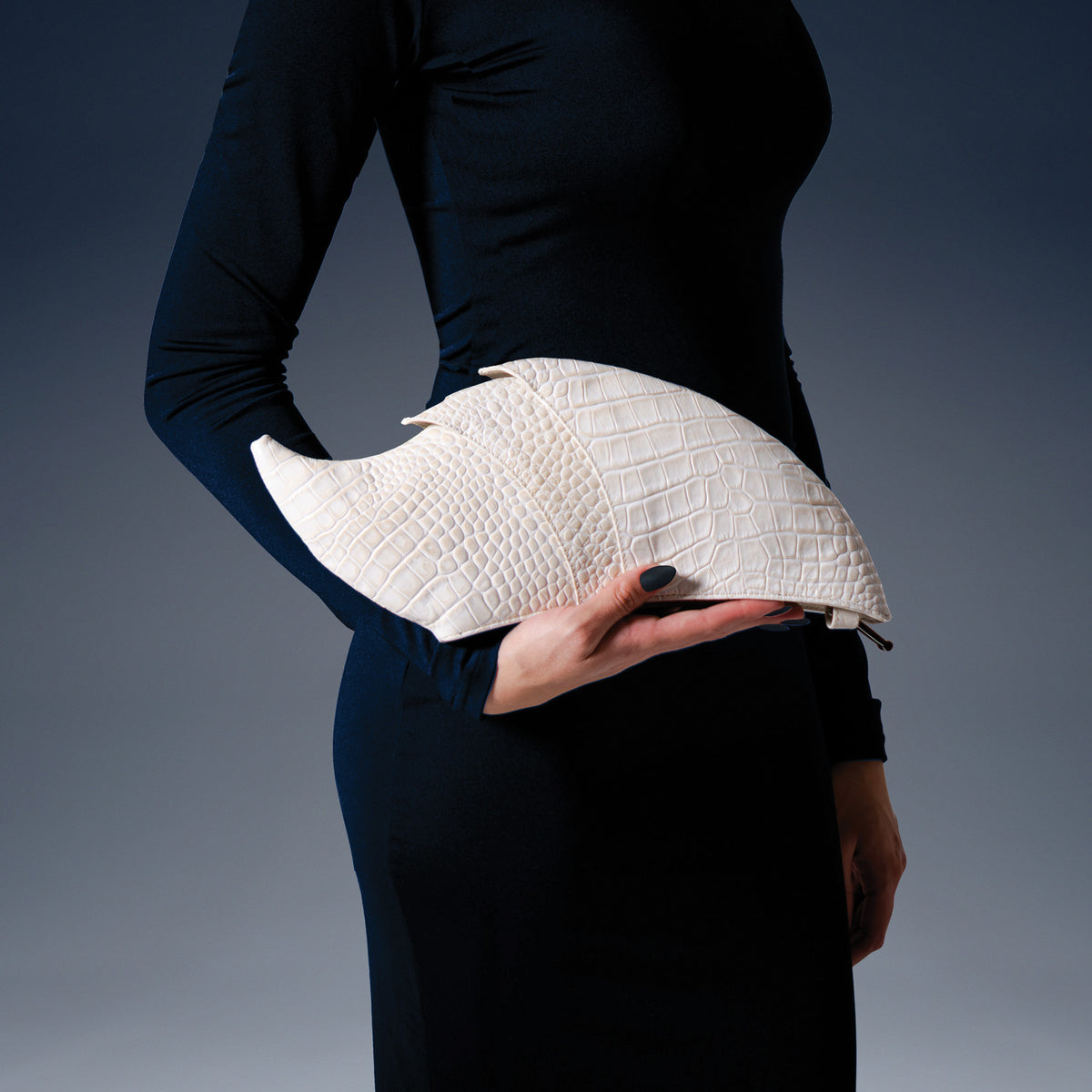 Model wearing a black dress with the Armadillo Clutch Oat