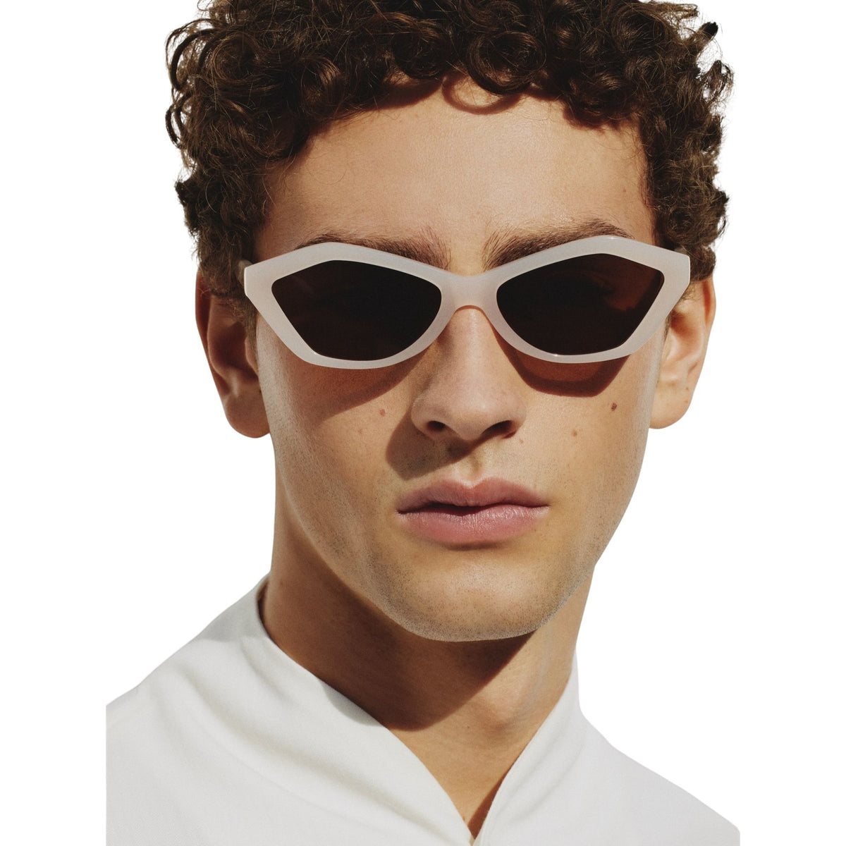 Person wearing a pair of sunglasses with a white frame on a white background
