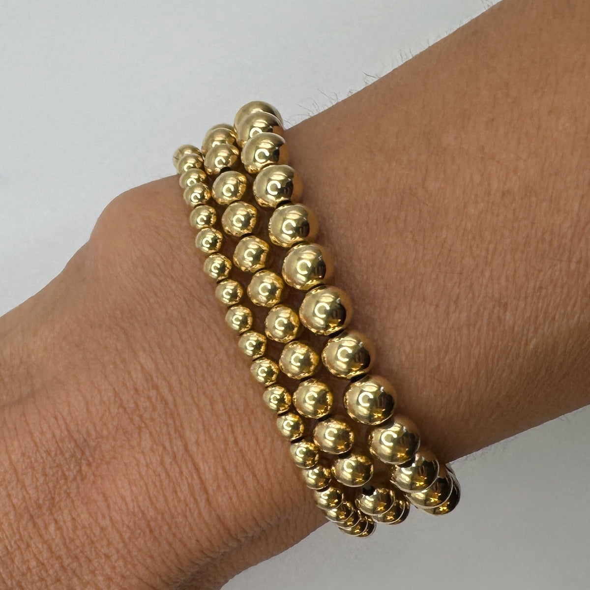 NART gold stackable bracelet 4mm worn by model, stacked gold-plated bracelets, buy at DOORS NYC