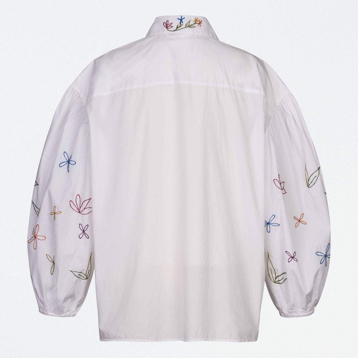 White shirt with colorful floral embroidery on a white background
