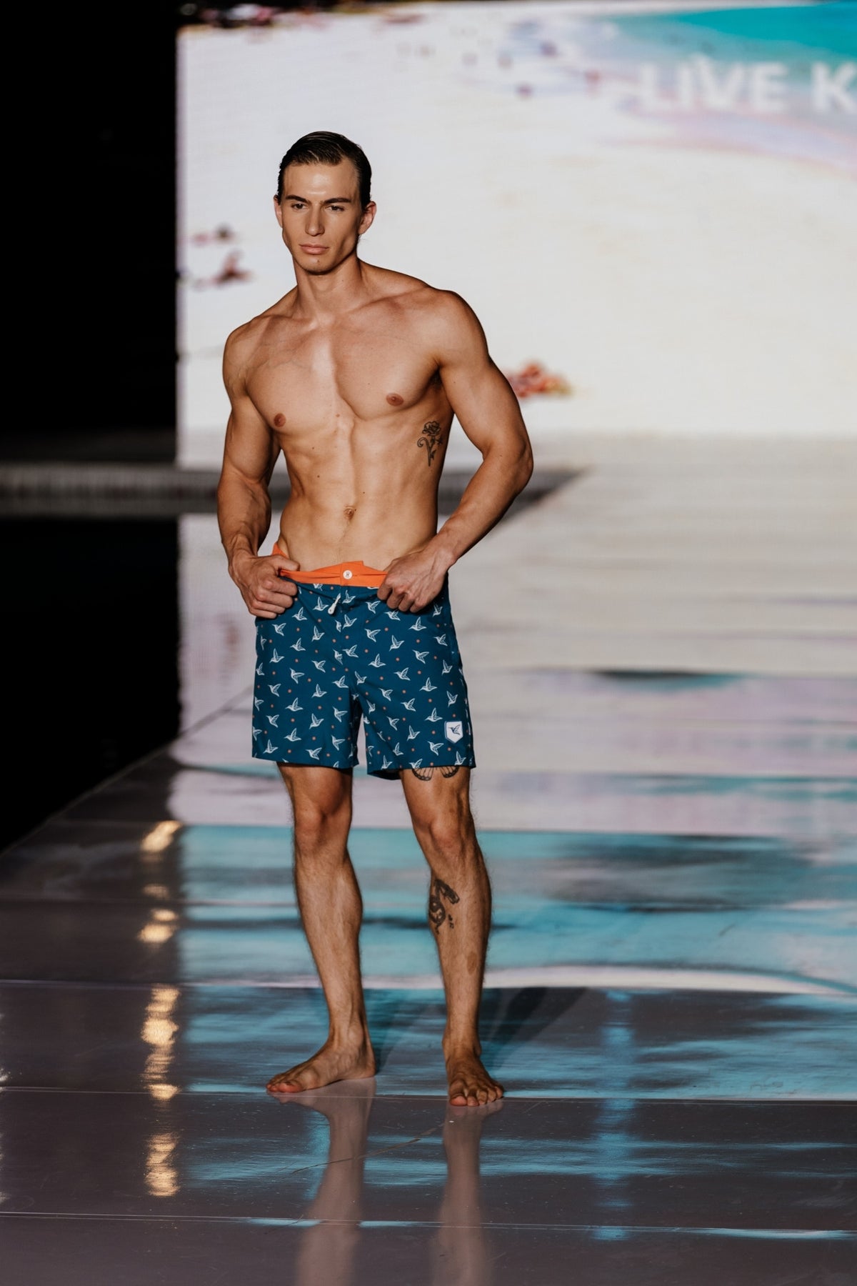 Model wearing Deep Ocean monogram swim trunks