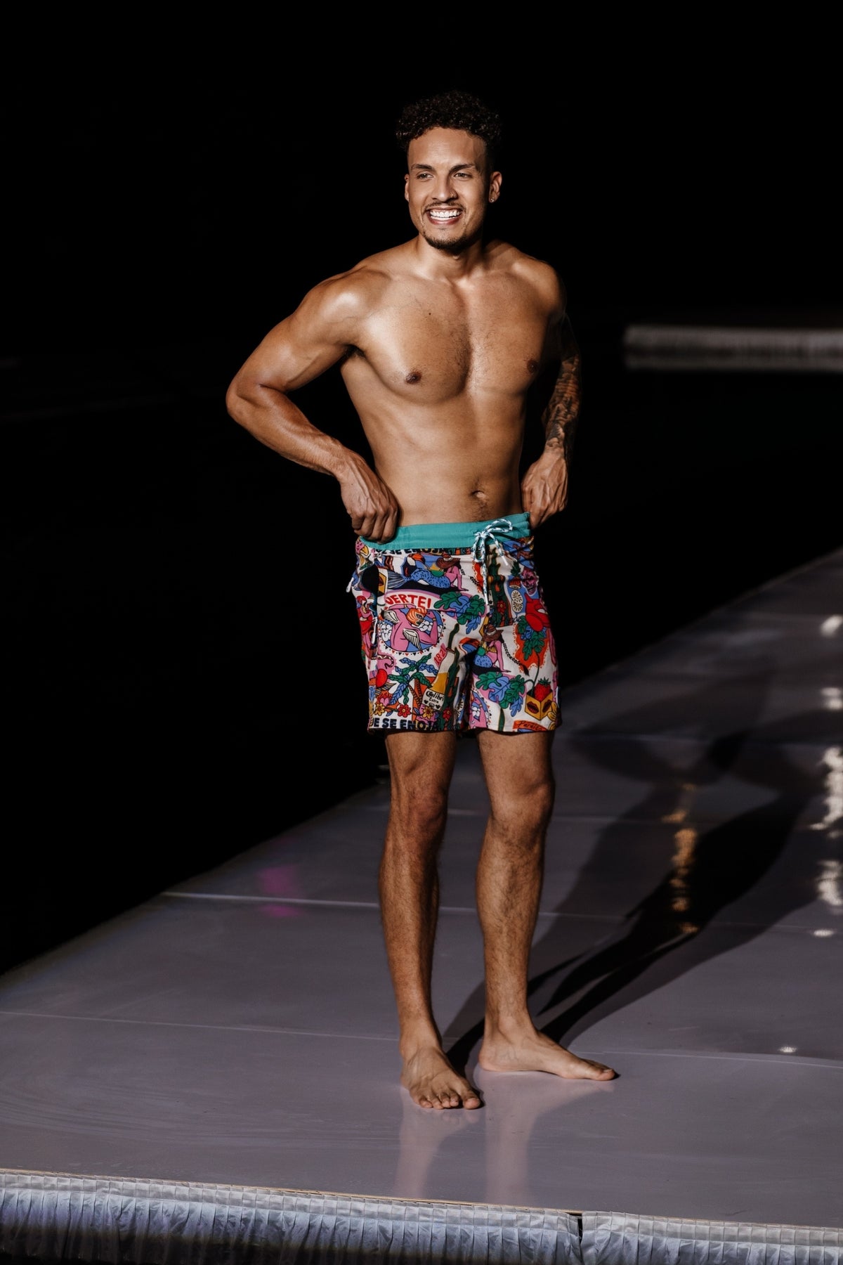 Model wearing bold Fuerte print swim shorts